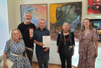 Irina Pokladova, Vladimir Matveïev, Nikolaï Kouzmine, Mila Sapojnikova-Douk, Liouba Kouzmina, devant les tableaux de Nikolaï Kouzmine : (à gauche) Champ de pommes de terres, 2022, H/t ; (à droite) Échappé de captivité, 2022, H/t.